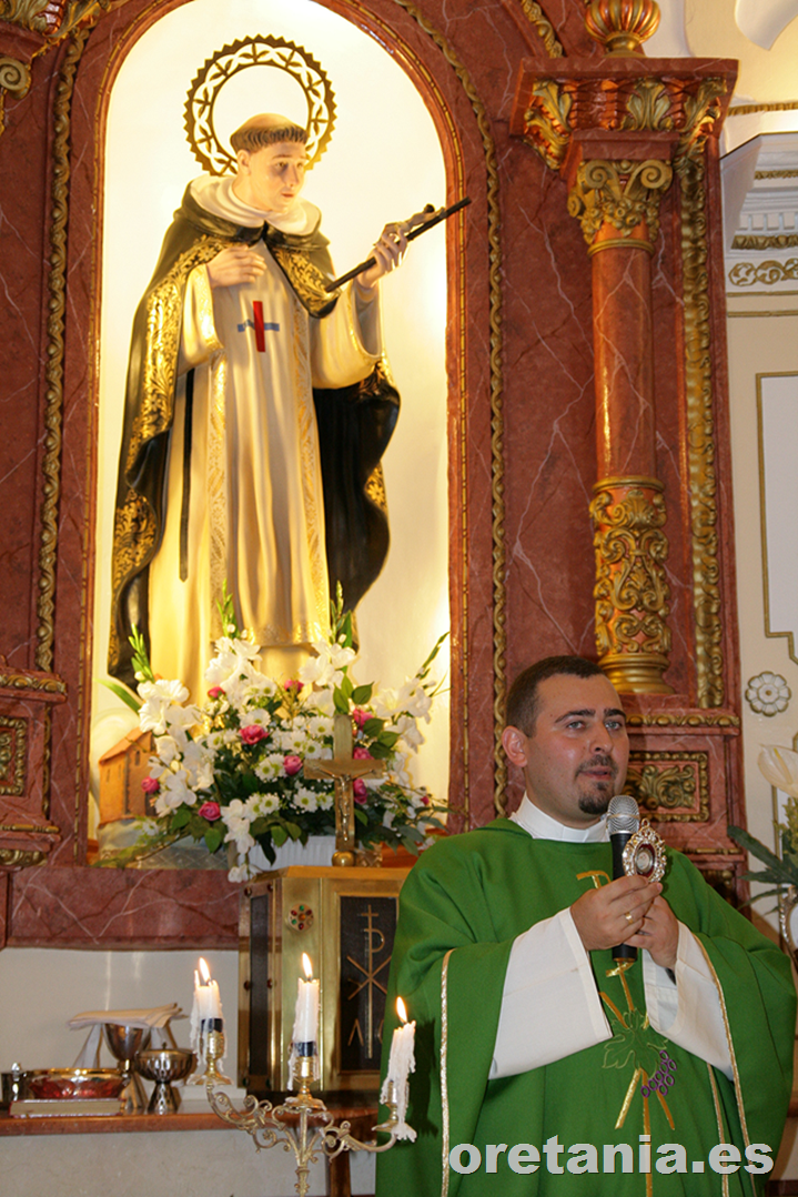 El padre trinitario Manuel, mostrando la reliquia donada en el altar que preside la imagen del patrón.