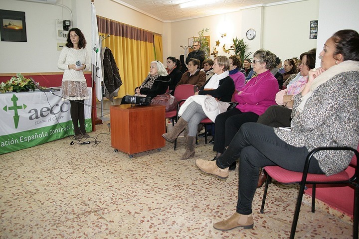 En primer término, a la derecha, la presidenta local sigue las explicaciones de la psicóloga de la AECC provincial