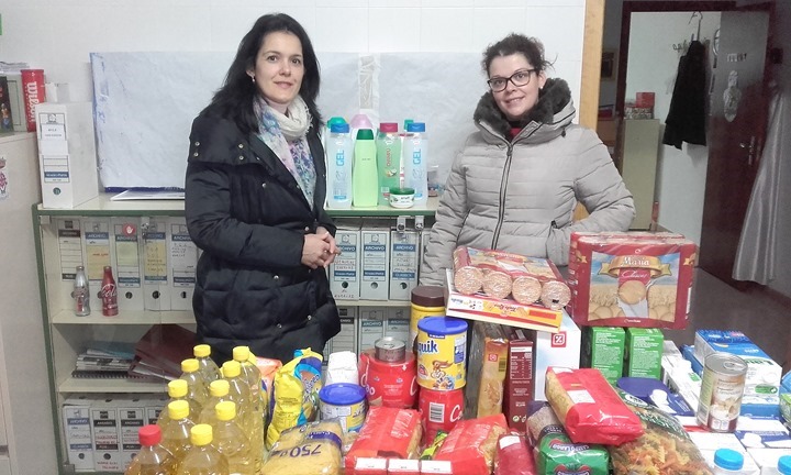 La directora entrega los alimentos a la responsable de Servicios Sociales