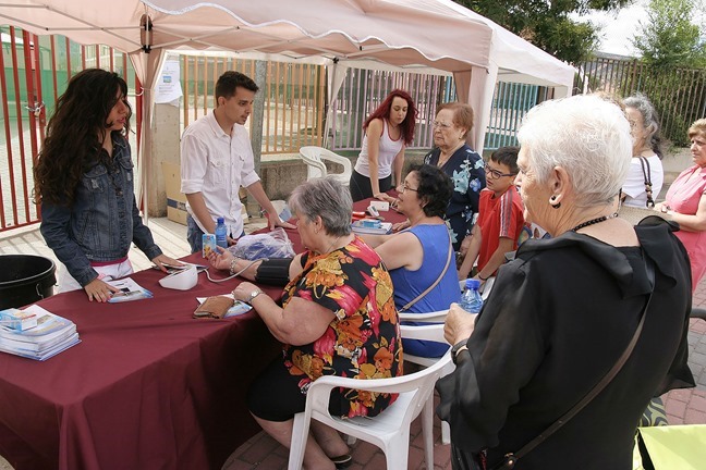 Varias personas sentadas a las que le tomaban la tensión