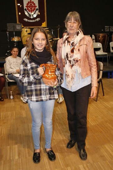 Graci Arias entregando una de las jarras a una de las alumnas