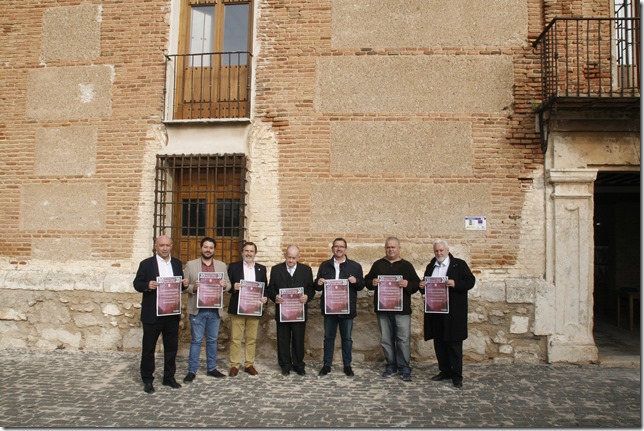 Mostrando el cartel del certamen los participantes en la presentación posan a las puertas del Palacio de Clavería en Aldea del Rey